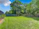 Large grassy backyard with mature trees and wooden fence at 2512 Regatta Dr, Sarasota, FL 34231