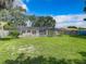 Spacious backyard with a screened pool, lush lawn, and wooden fence at 2512 Regatta Dr, Sarasota, FL 34231