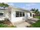 White single story house with large windows, a patio, and well-maintained lawn at 352 Gardenia Rd, Venice, FL 34293