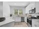 Well-equipped kitchen featuring white cabinets, stainless steel appliances, and a large window at 4008 Via Sienna Cir, Sarasota, FL 34243