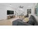 Open living space with hardwood floors, sectional sofa, and a large TV at 4008 Via Sienna Cir, Sarasota, FL 34243