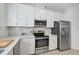 Modern kitchen with white cabinets, stainless steel appliances and quartz countertops at 4008 Via Sienna Cir, Sarasota, FL 34243
