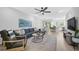 Open living room with hardwood floors, sectional sofa, and access to kitchen at 4008 Via Sienna Cir, Sarasota, FL 34243