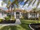 Beautiful home exterior with lush landscaping and palm trees at 588 Sawgrass Bridge Rd, Venice, FL 34292