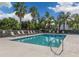 Community pool with lounge chairs and red umbrellas at 900 San Lino Cir # 922, Venice, FL 34292