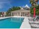 Community pool with lounge chairs, red umbrellas, and adjacent building at 900 San Lino Cir # 922, Venice, FL 34292