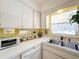 Corner kitchen with white cabinets and yellow gingham backsplash at 210 Park N Blvd # 129, Venice, FL 34285