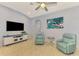 Bright living room with two teal armchairs and a large TV at 225 Auburn Woods Cir, Venice, FL 34292