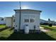 Rear view of a white mobile home showcasing a propane tank and grassy area at 227 Inner E Dr, Venice, FL 34285