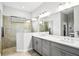 Elegant bathroom with dual vanity, large mirror, and a walk-in shower at 26628 Irwin Dr, Englewood, FL 34223