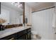 Modern bathroom with dark vanity, stone countertop, and shower at 3524 Brownwood Ter, North Port, FL 34286