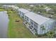 Aerial view of condo building with lake and green space at 404 Cerromar N Cir # 315, Venice, FL 34293