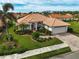 Single-story home with tile roof, lush landscaping, and a paved driveway at 4361 Via Del Santi, Venice, FL 34293