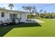Lush backyard with artificial turf, an outdoor seating area, and manicured landscaping at 510 Harbor S Dr, Venice, FL 34285