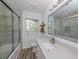 Bright bathroom with wood look floors, shower-tub with sliding doors, and a large, framed mirror at 510 Harbor S Dr, Venice, FL 34285