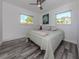 Light and bright bedroom with a ceiling fan, wood look flooring, and two windows at 510 Harbor S Dr, Venice, FL 34285