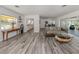 Open-concept living space featuring grey wood floors and access to kitchen and sunroom at 510 Harbor S Dr, Venice, FL 34285