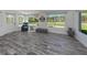 Bright sunroom with view of backyard, gray wood-look floors, and comfy seating at 510 Harbor S Dr, Venice, FL 34285