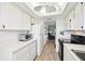 White kitchen cabinets, new flooring, and view into living room at 6796 Gasparilla Pines Blvd # 62, Englewood, FL 34224
