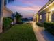 Landscaped backyard with walkway leading to pool area at sunset at 75 Cayman Isles Blvd, Englewood, FL 34223