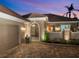 Elegant home entrance with paver driveway and decorative gate at dusk at 75 Cayman Isles Blvd, Englewood, FL 34223