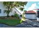 Landscaped entryway with lush greenery and a pathway leading to a garage at 784 Sarabay Rd # 18, Osprey, FL 34229
