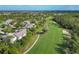 An aerial view showcases lush golf course frontage adjacent to residential community at 815 Montrose Dr # 103, Venice, FL 34293