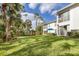Expansive lawn and trees viewed from the backyard with a small patio under the screened in lanai at 815 Montrose Dr # 103, Venice, FL 34293