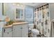 Well-lit bathroom featuring a vanity with ample storage and a shower with coastal-themed curtains at 815 Montrose Dr # 103, Venice, FL 34293