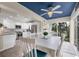 Bright dining room with blue ceiling, white table set, and an updated kitchen in the background at 815 Montrose Dr # 103, Venice, FL 34293