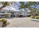 Condo complex featuring mature trees, covered parking, and a welcoming entrance at 815 Montrose Dr # 103, Venice, FL 34293