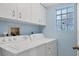 Functional laundry room with a modern washer and dryer and ample storage cabinets at 815 Montrose Dr # 103, Venice, FL 34293