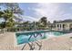 A pristine community pool is surrounded by lounge chairs and lush landscaping on a sunny day at 815 Montrose Dr # 103, Venice, FL 34293