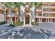 Elegant building entrance with palm trees and paved pathway at 830 The Esplanade N # 203, Venice, FL 34285