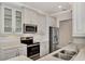 Modern kitchen with stainless steel appliances and white cabinets at 830 The Esplanade N # 203, Venice, FL 34285