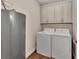 Laundry room with washer, dryer, cabinets, and water heater at 830 The Esplanade N # 203, Venice, FL 34285