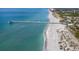 Aerial view of a beach with pier, turquoise water, and people enjoying the sand at 885 Country Club Cir # 61, Venice, FL 34293