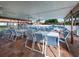 Covered patio with tables and chairs near the community pool at 885 Country Club Cir # 61, Venice, FL 34293