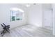 Empty spare bedroom with wood-look floors and an arched window at 8920 Bantry Bay Blvd, Englewood, FL 34224