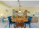 Charming dining room with wooden table and blue chairs, featuring coastal-themed artwork at 1018 Beach Manor Cir # 40, Venice, FL 34285