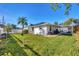 Backyard view showcasing a spacious grassy area, solar panels, and screened enclosure at 1030 Phorus Rd Rd, Venice, FL 34293