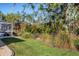 Backyard view showing a screened enclosure, lush greenery, and a chain link fence at 1030 Phorus Rd Rd, Venice, FL 34293