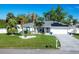 House exterior showcasing a well-maintained lawn, palm trees, and solar panels at 1030 Phorus Rd Rd, Venice, FL 34293