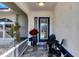 Inviting front porch with tiled floor and small sitting area at 1030 Phorus Rd Rd, Venice, FL 34293