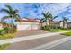 Two-story house with three-car garage, palm trees, and brick driveway at 10829 Whisk Fern Dr, Venice, FL 34293