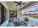 Covered patio with comfortable seating overlooking the pool and canal at 10829 Whisk Fern Dr, Venice, FL 34293