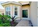 Front entry with green door, brick walkway, and landscaping at 11394 Dancing River Dr, Venice, FL 34292