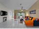 Living room with an orange sectional sofa and a large TV at 11449 Claggett Ave, Port Charlotte, FL 33981