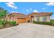 Orange home with tile roof, two-car garage, and landscaped yard at 1151 Creek Nine Dr, North Port, FL 34291