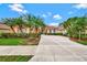 Mediterranean style home with palm trees and manicured lawn at 1151 Creek Nine Dr, North Port, FL 34291